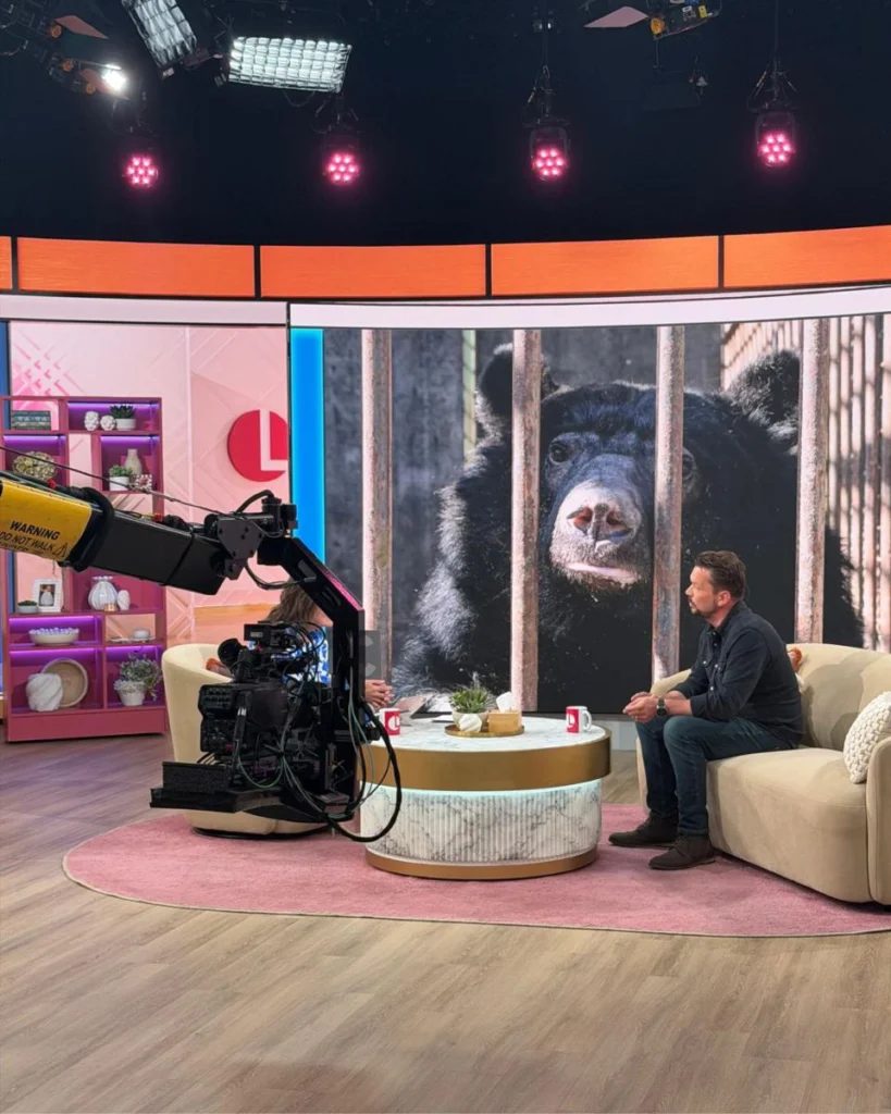 Jimmy Doherty on the Lorraine sofa with a moon bear image on the studio screen behind him